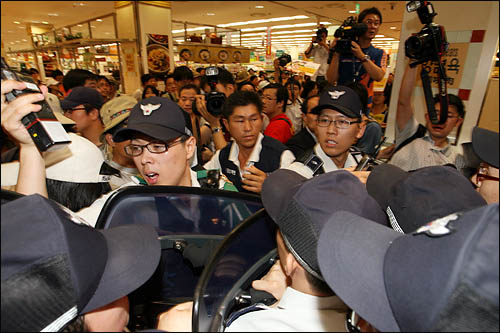 한미FTA에 반대하는 단체 회원들이 13일 오전 미국산쇠고기 판매를 시작한 롯데마트 서울역지점 매장 수입육 코너에서 "광우병 위험이 있는 미국산쇠고기 수입 판매 반대"를 외치며 시위를 벌이자 이들을 막는 경찰과 몸싸움을 벌이고 있다. 